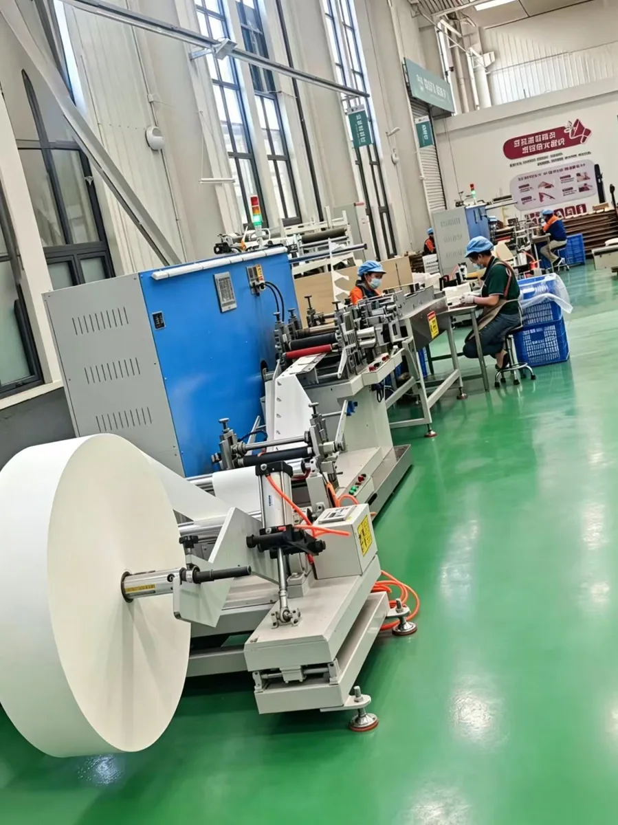 Paper roll converting equipment and operators inside the Zhongji Paper factory