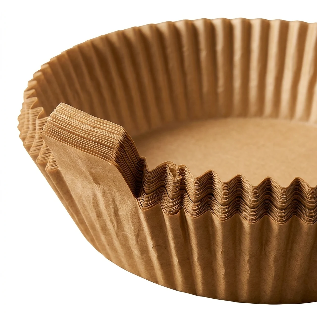 Close-up of the pleated rim and lifting tab on stacked natural-color air fryer liners.