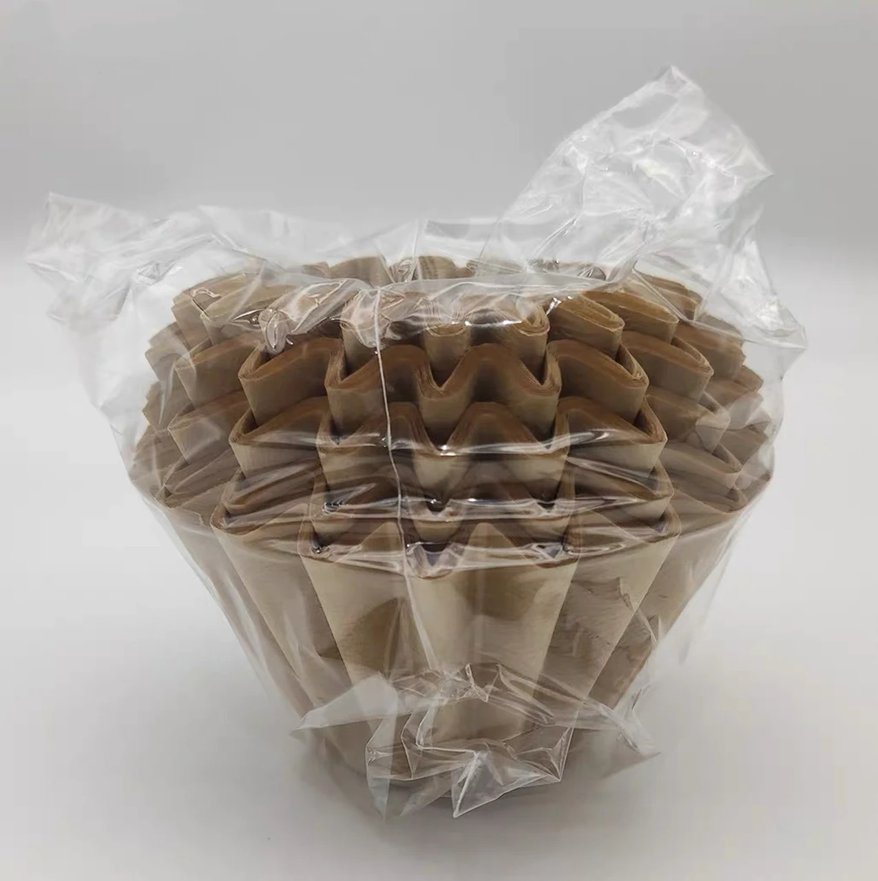 Natural-color pleated basket coffee filters packed in a clear bag.