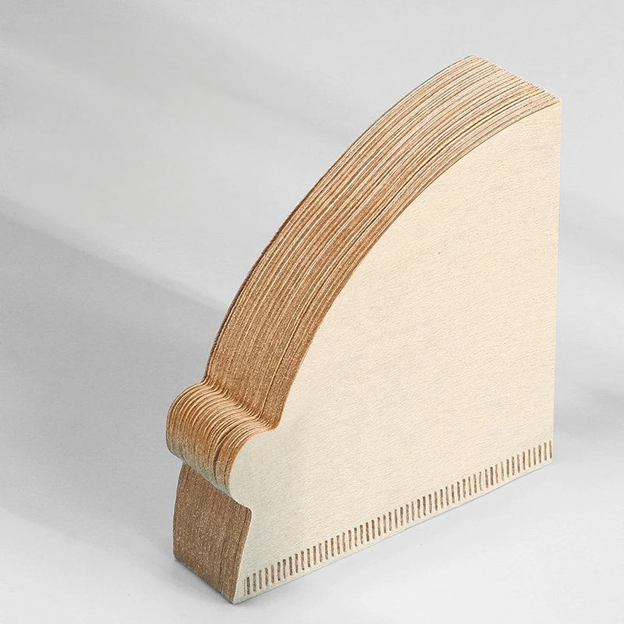 Stack of natural-color cone coffee filters with the sealed edges visible.