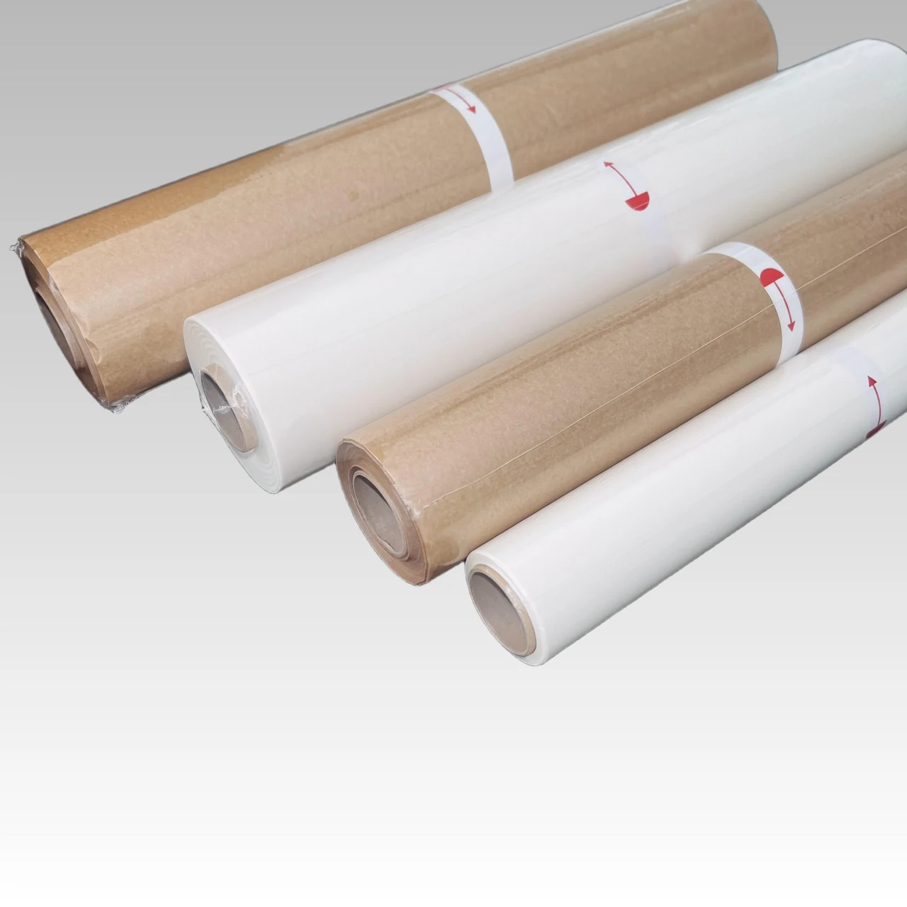 Natural-color and white baking paper rolls in clear protective wrapping.