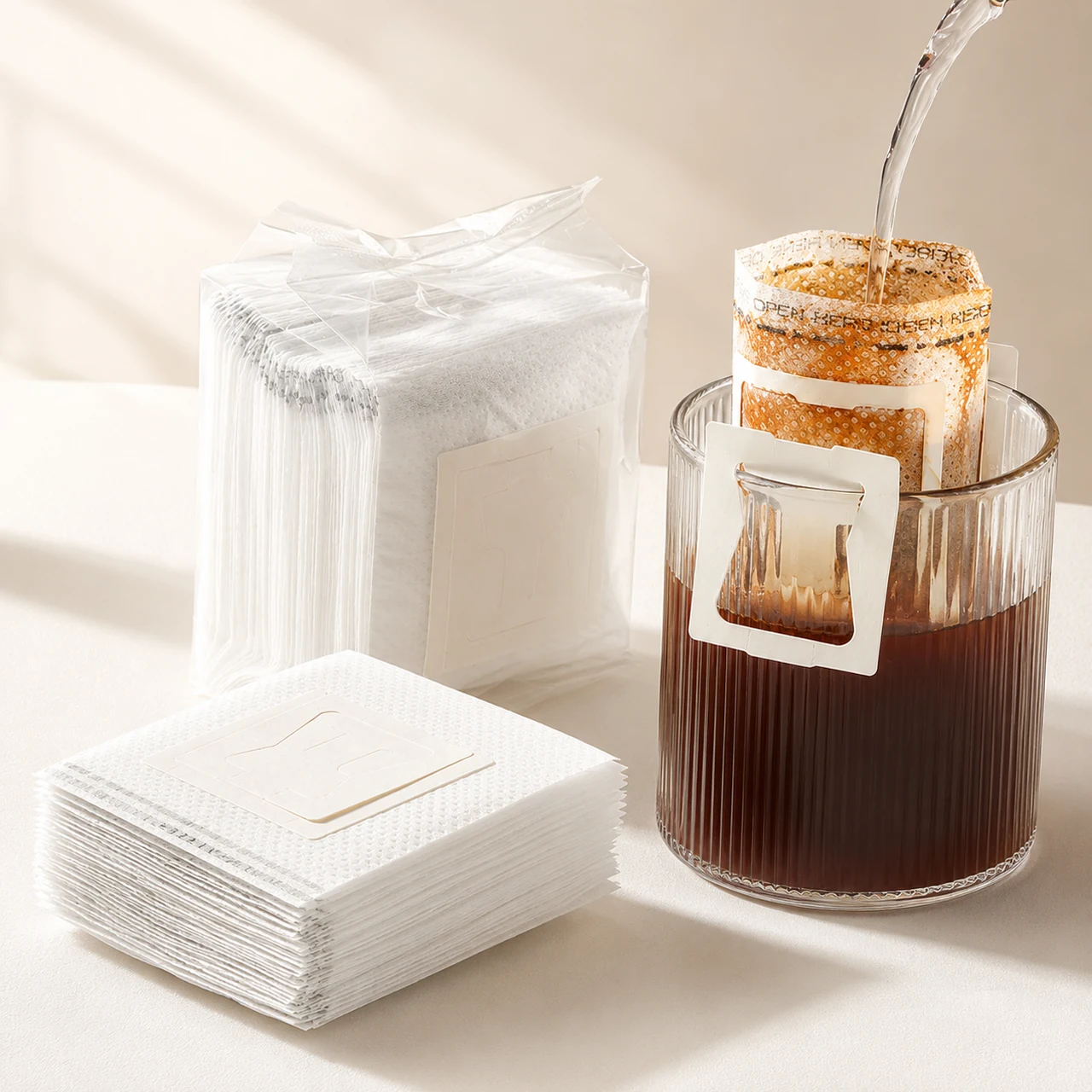 Drip coffee filter bag brewing over a glass beside loose and bagged filters.