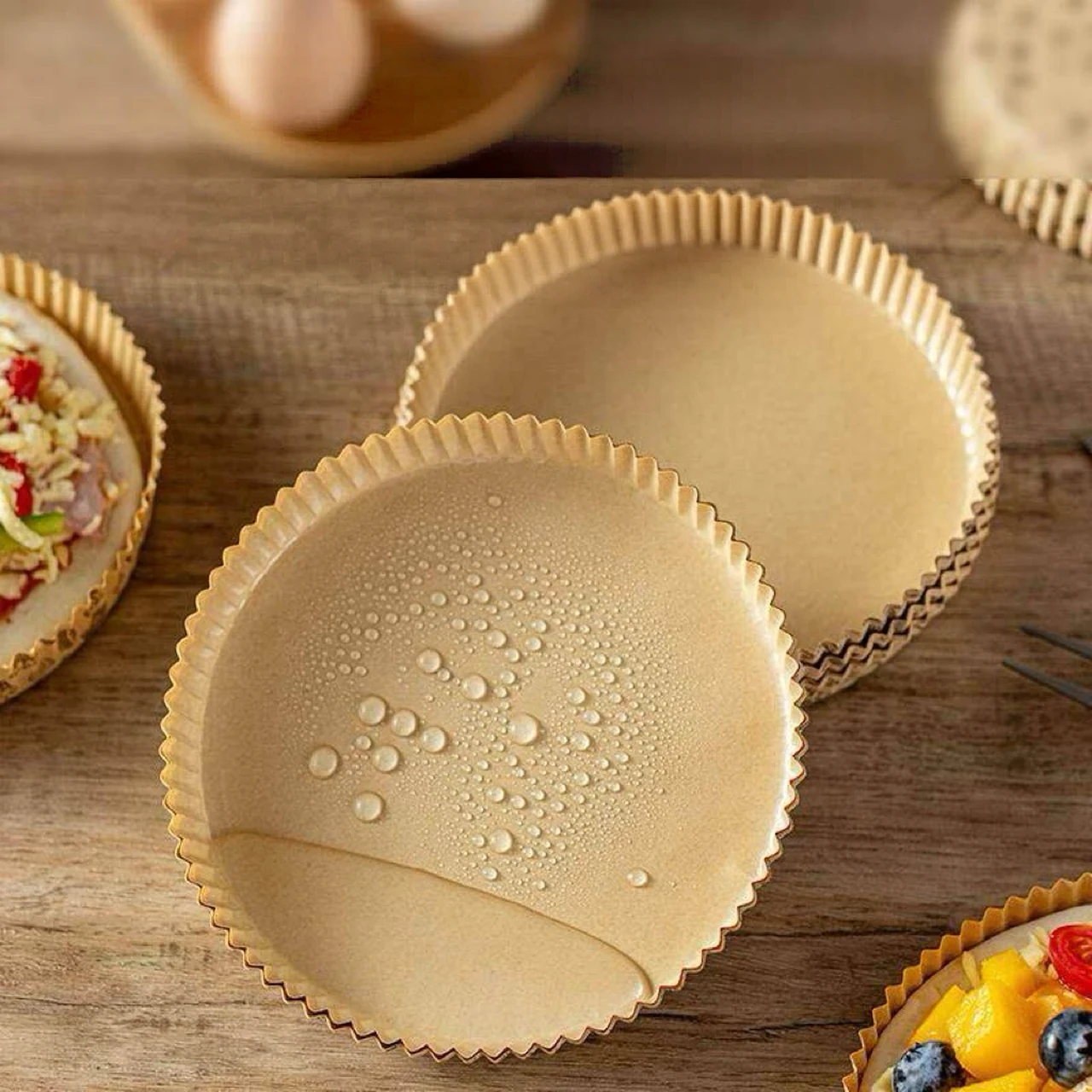 Plateaux à pizza en papier de couleur naturelle avec des gouttelettes visibles sur celui de devant.