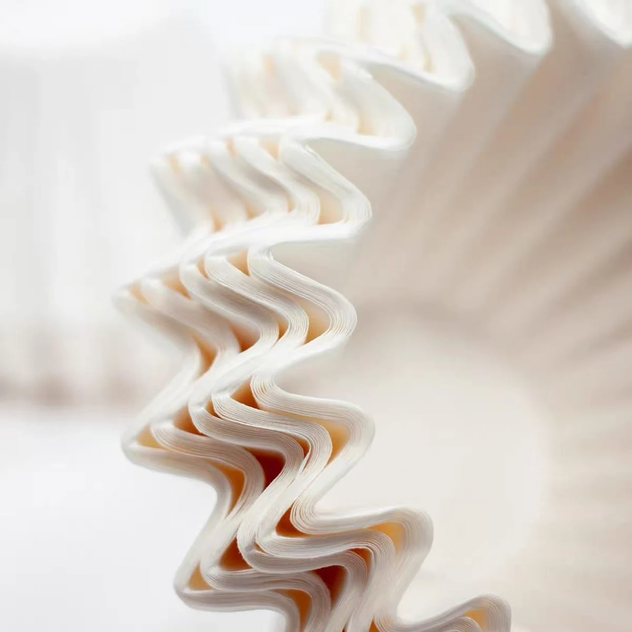 Close-up of the pleated edges of white basket coffee filters.