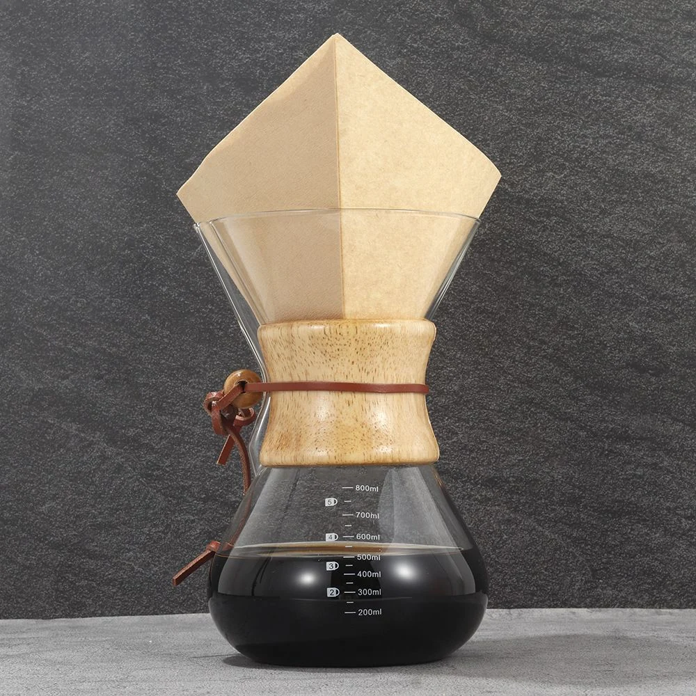 Brown folded square coffee filter placed in a glass coffee brewer.