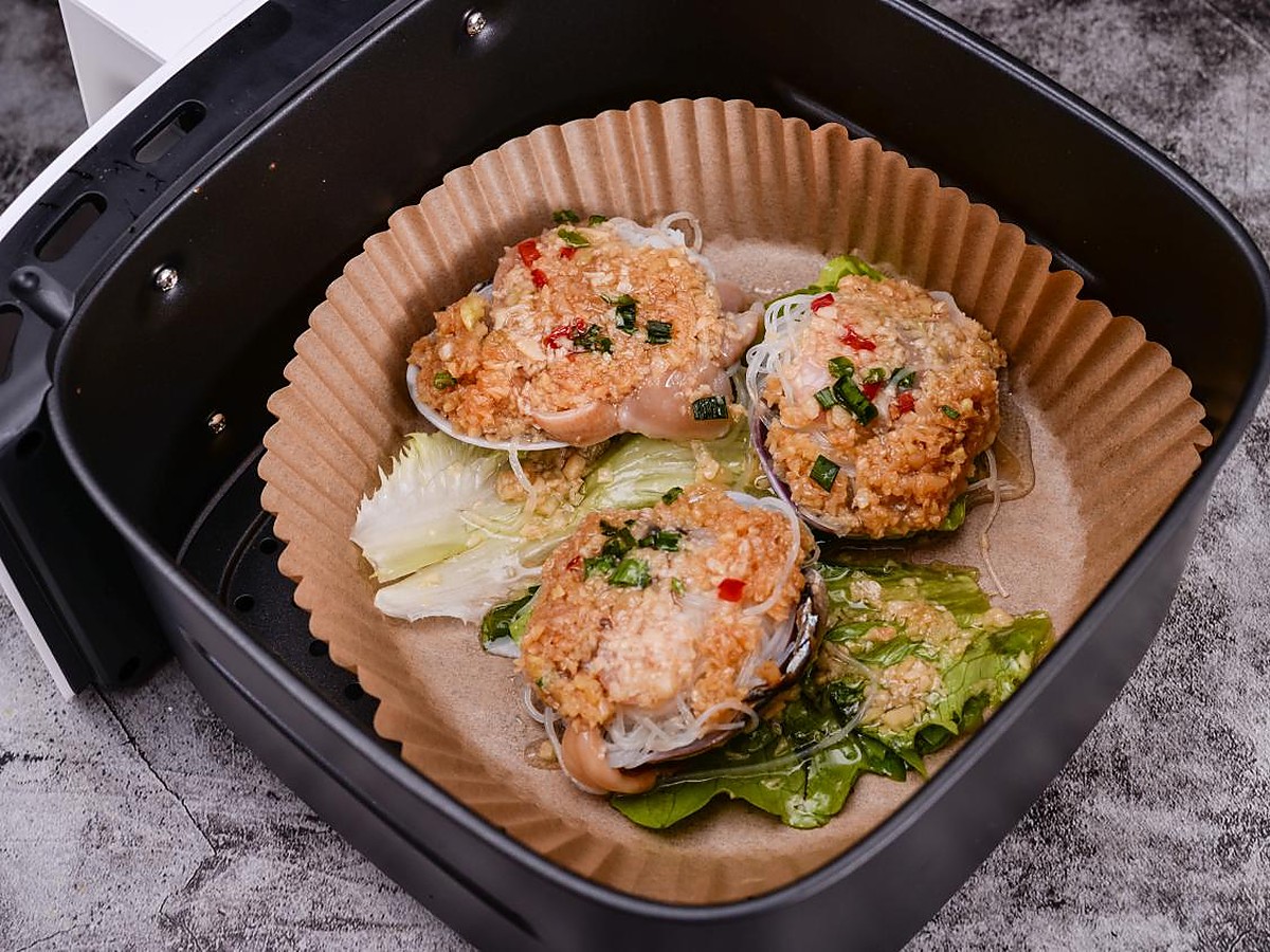 Air fryer paper liner placed in an air fryer with food