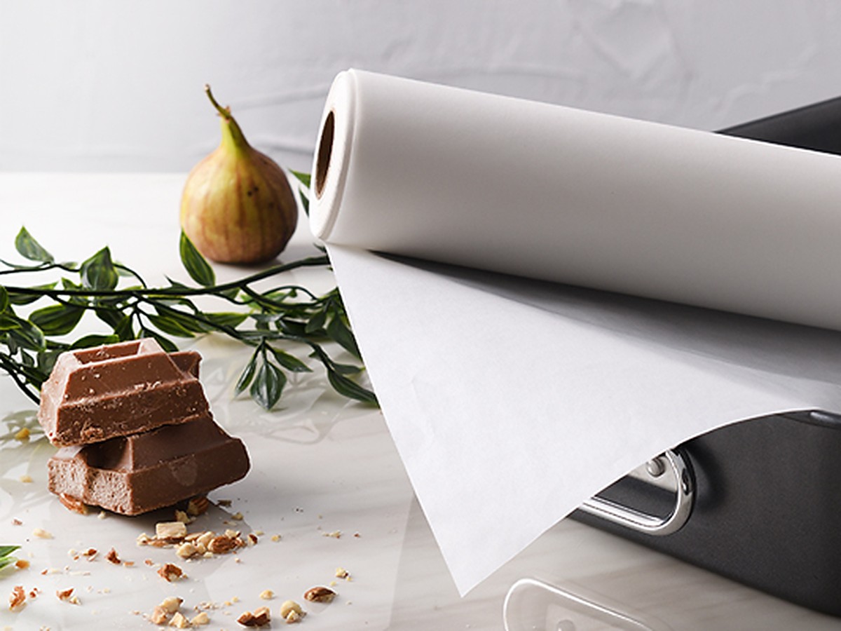 White parchment paper roll and baking paper sheet on a clean table